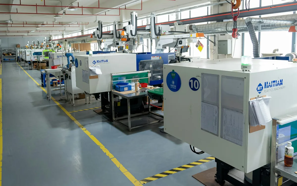 Yan yana yerleştirilmiş plastik enjeksiyon makinelerinin bulunduğu üretim hattı